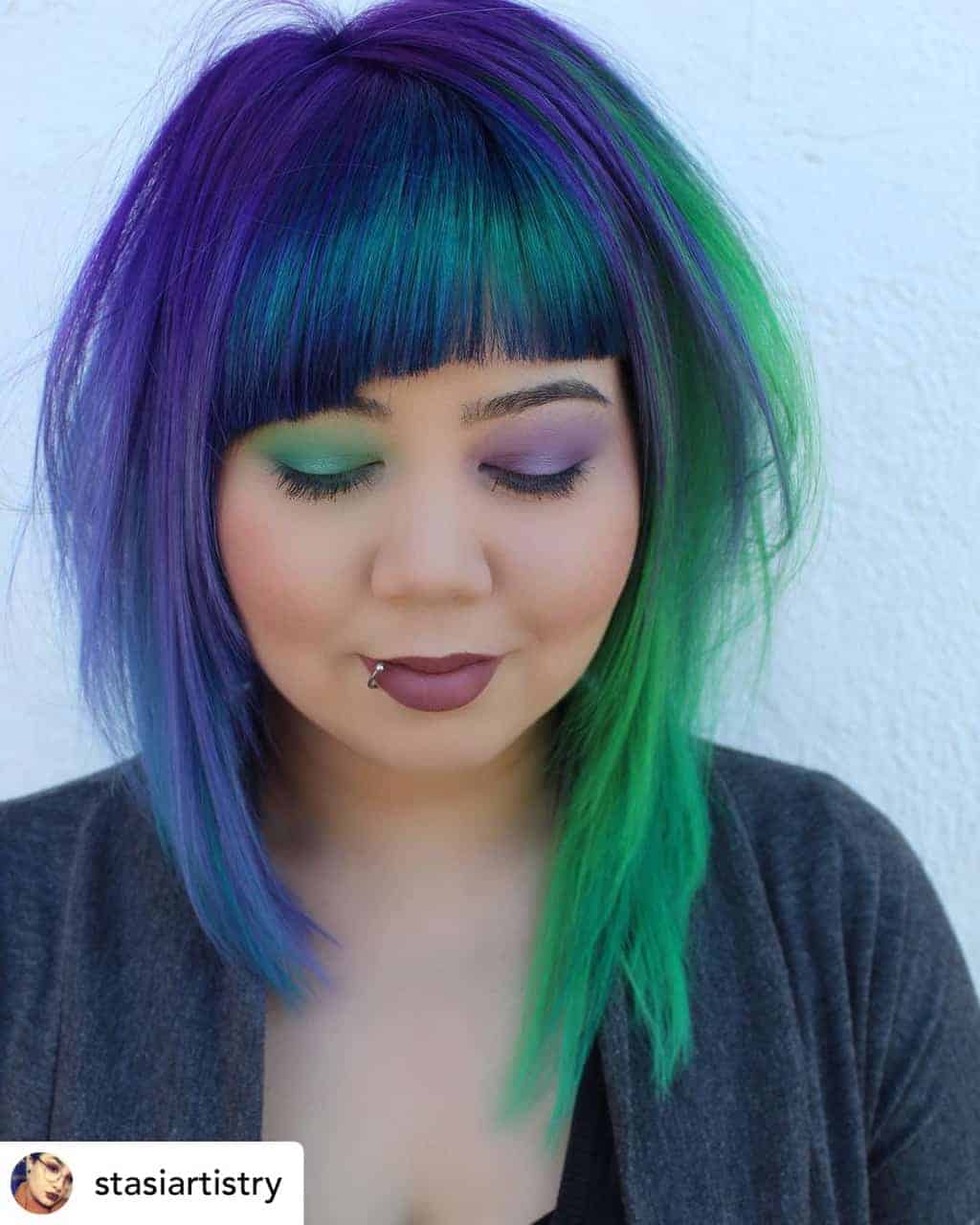 Asymmetrical bangs on beautiful green and blue hair.