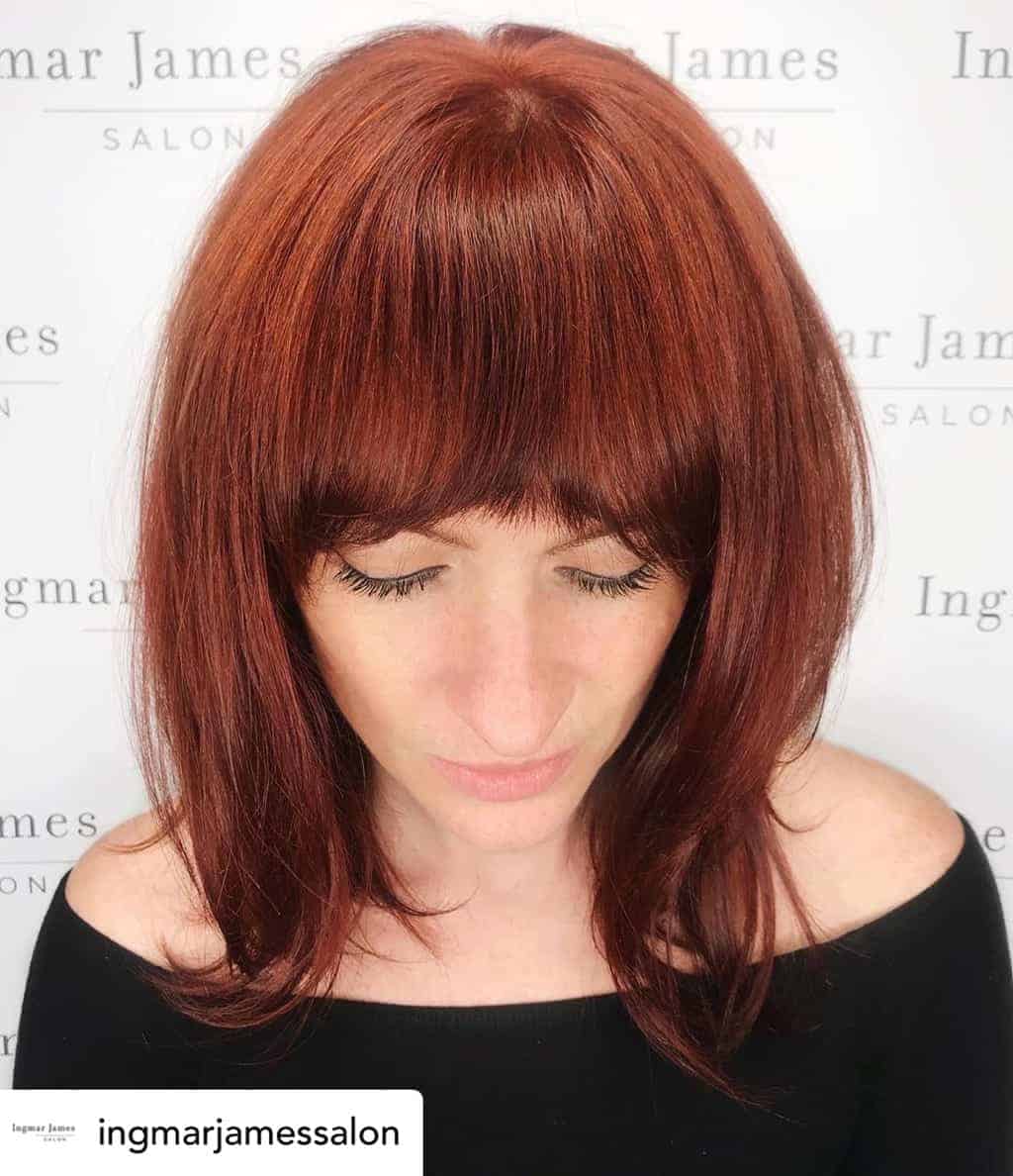 Curtain bangs on beautiful auburn hair.